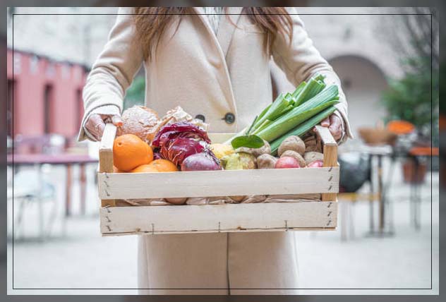 woman carrying a tray of organic vegetables